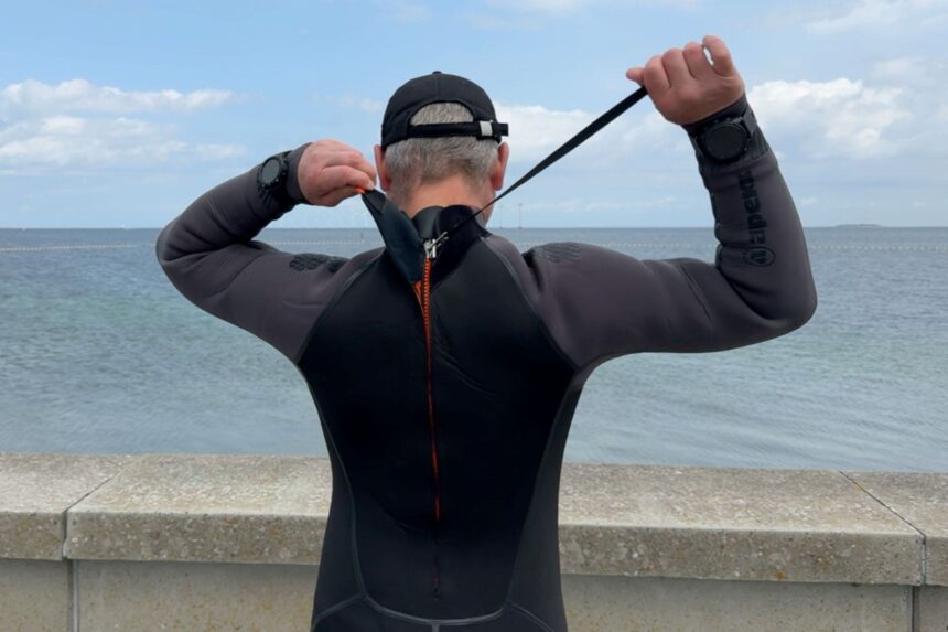 Our tester pulling the back zipper leash of the Apeks ThermiQ 5 mm wetsuit closed on his own