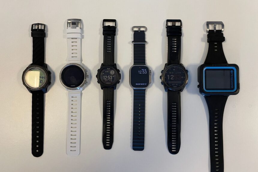Six smartwatch dive computers laid out side by side on a white surface for comparison