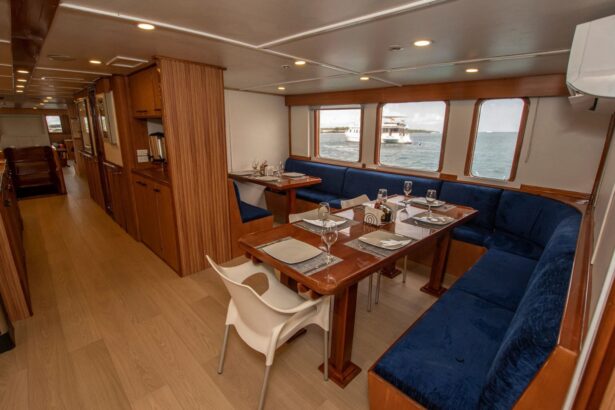 Indoor dining area with wood tables, blue upholstered benches and ocean-view windows