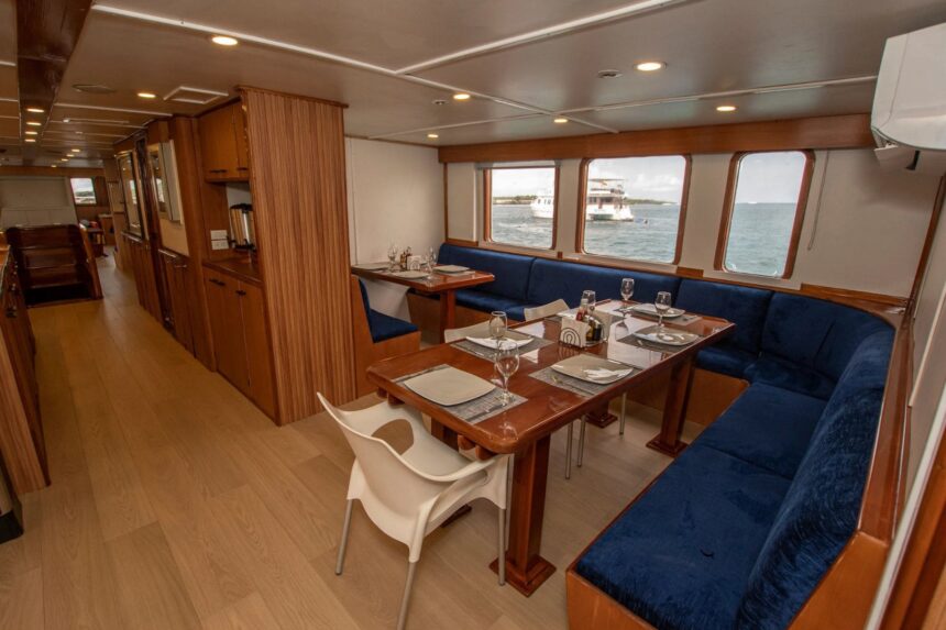 Indoor dining area with wood tables, blue upholstered benches and ocean-view windows