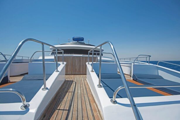 Bow deck of the liveaboard with railings and cushioned teak sunbeds