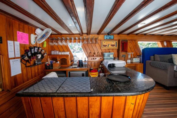 Wood-paneled onboard bar with hanging glasses, a digital clock and a granite counter