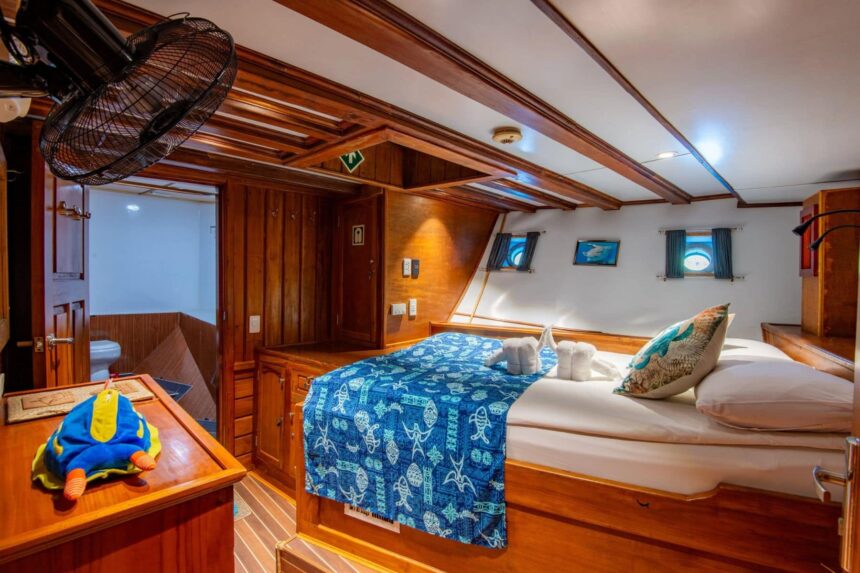 Ensuite cabin aboard the Palau Siren with a double bed and folded towels