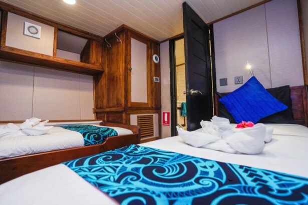 Twin cabin aboard the Solomons Master with towel art and a tropical flower on the bed