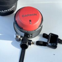 The Garmin Descent S1 Buoy unit, dive computer and mounting hardware laid out on a white surface