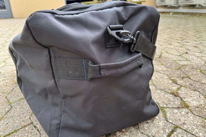 End panel of the Scuba.com Big Duffel with its metal D ring and clipped shoulder strap