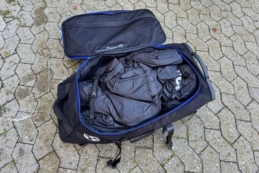 Open wheeled Stahlsac dive bag packed with black gear, blue trim around the lid