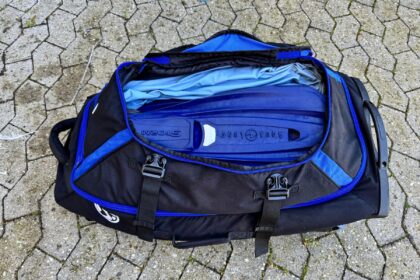Stahlsac Curacao Clipper duffel opened to show an Aqua Lung Storm BCD and wetsuit packed inside
