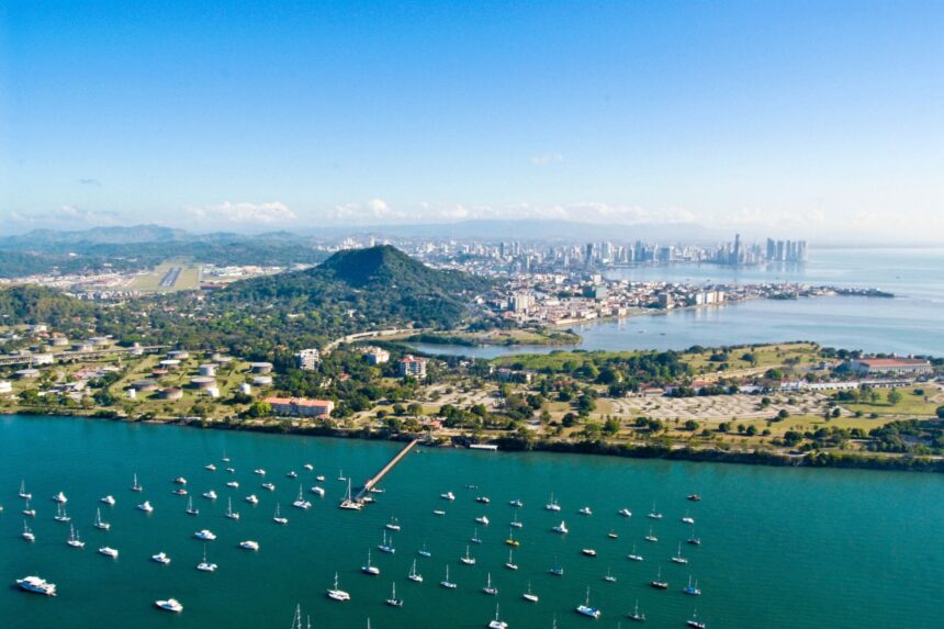 Aerial view of Panama City with sailboats moored along the green coastline and the skyline behind