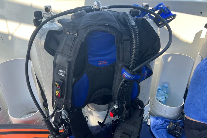 Mares Magellan Mounted On The Cylinder Mares Magellan BCD strapped to a cylinder on the boat deck, front view with inflator hose over the shoulder