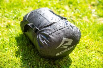 Sea to Summit EVAC Compression HD dry bag cinched down on grass, covered in water droplets