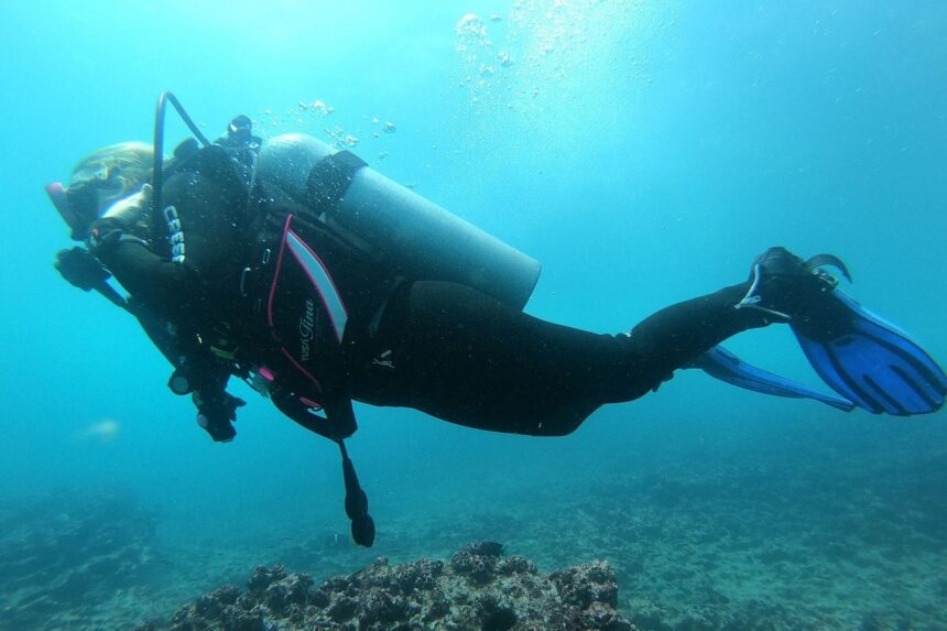 TUSA Tina On A Reef Dive Our tester swimming over a reef in clear blue water wearing the TUSA Tina BCD