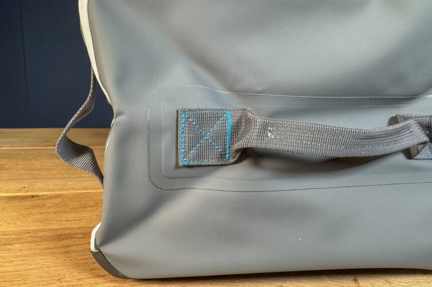 Close-up of a grab handle anchored to the Abyss duffel with blue cross stitching