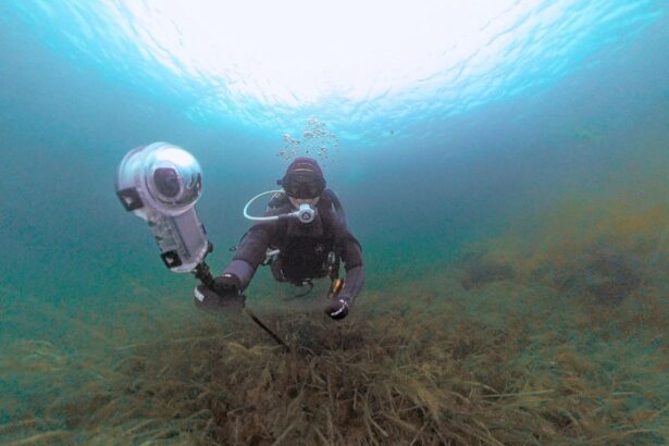DIVEIN tester filming with the Insta360 X5 in its dive case above a seagrass bed