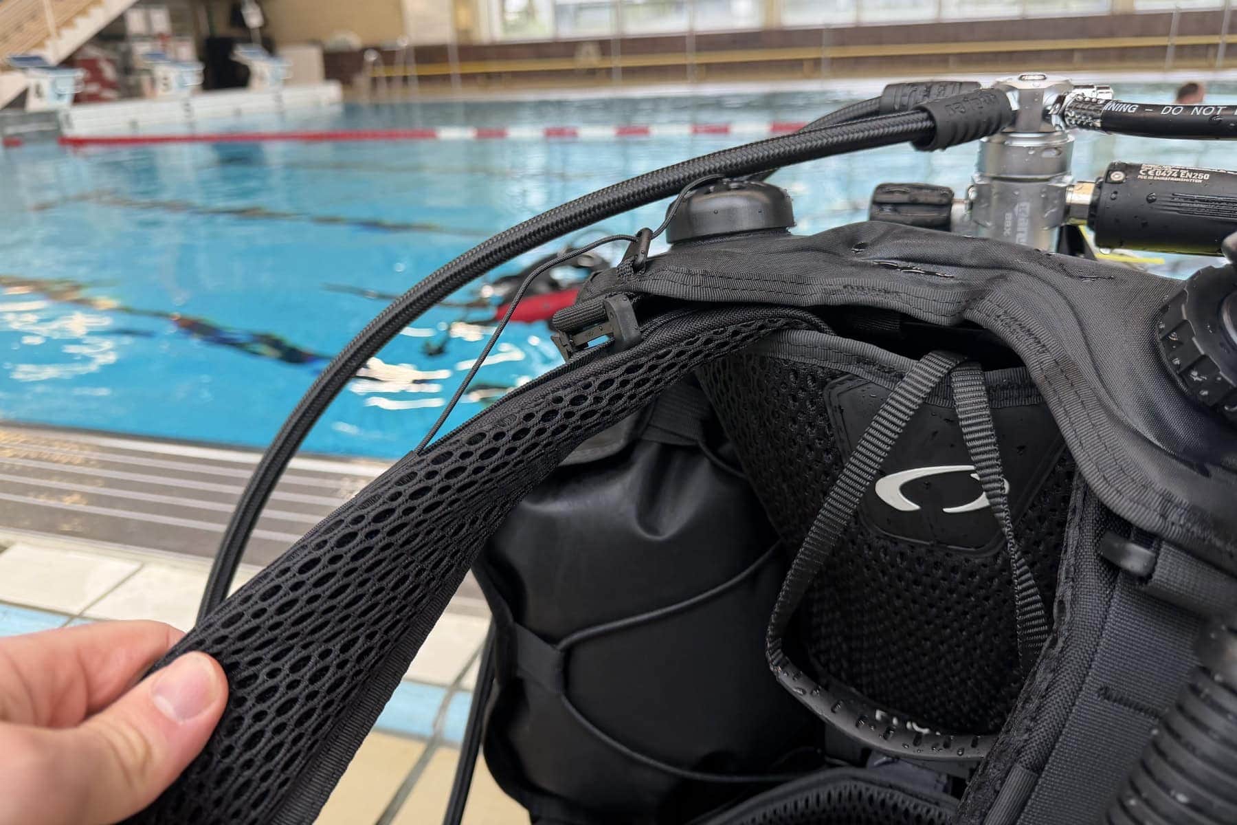 Our reviewer lifting the quick-dry mesh shoulder padding on the Oceanic Photon Pro at a pool