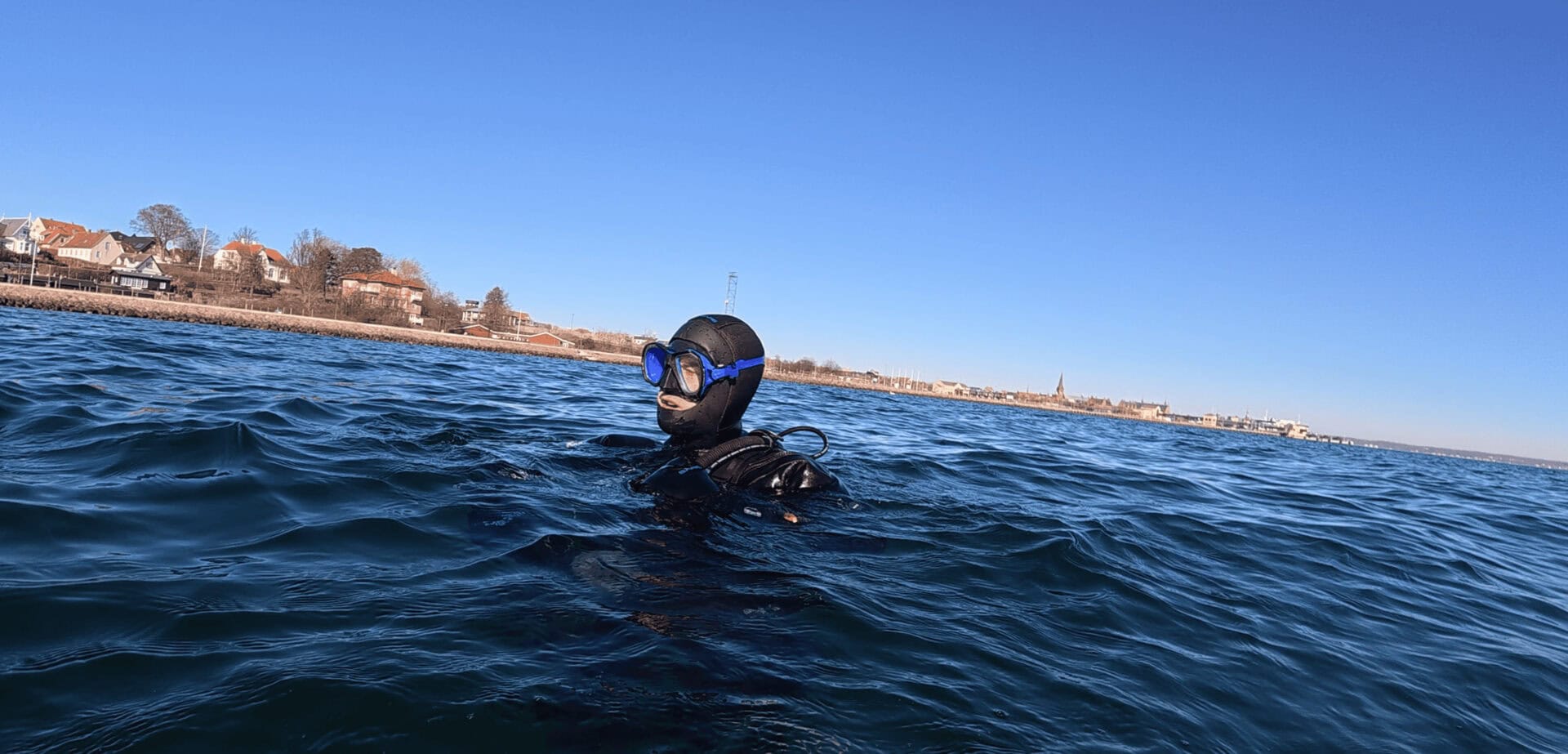 Our tester floating at the surface in the Oceanic Photon Pro with a coastline behind