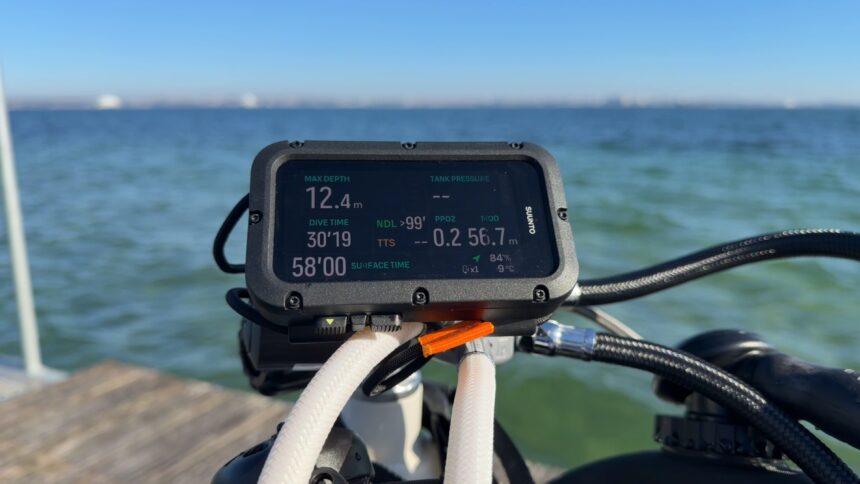 Suunto dive computer display showing depth, dive time, and gas readings on a boat