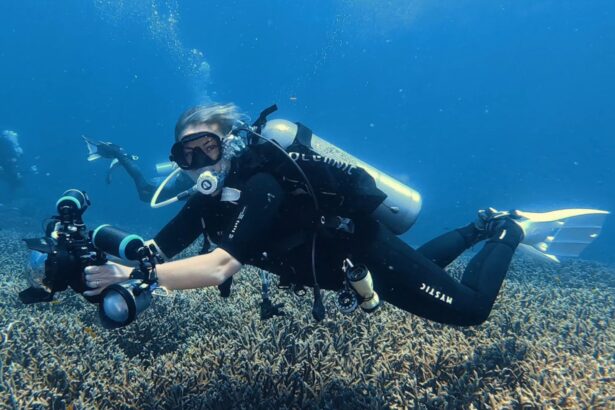 DIVEIN tester diving the Oceanic Photon Air BCD with a camera rig over coral
