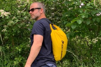 Our tester carrying the yellow Sea to Summit Lightweight dry bag slung over one shoulder on a walk