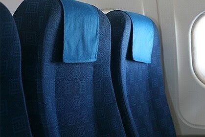 Airplane seats beside a window overlooking clouds during a flight