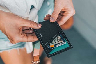 DIVEIN tester holds a Reborn Rubber recycled-wetsuit wallet while tucking away cash and a card