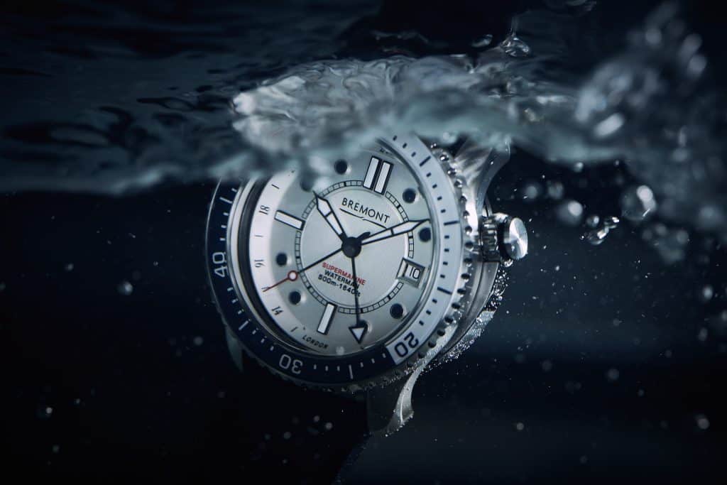 Bremont Waterman dive watch with a white dial and black bezel splashing into dark water