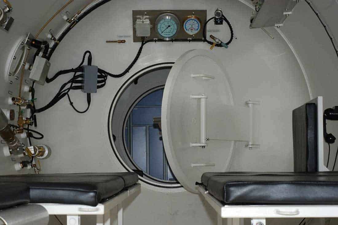 Interior of a hyperbaric recompression chamber with gauges and padded benches
