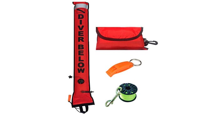Red inflatable DSMB safety buoy displayed with its carry pouch, safety whistle and finger spool