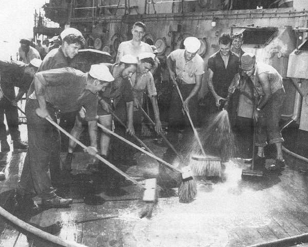 Sailors scrubbing down a ship's deck during the Operation Crossroads Baker test decontamination effort