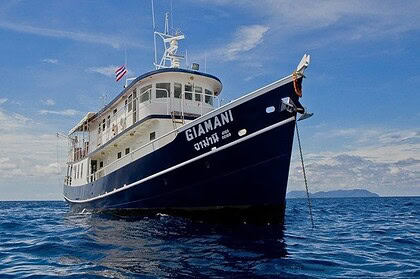 the liveaboard dive boat Giamani at anchor, viewed from the bow with its anchor chain visible