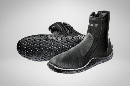 Pair of black Scubapro Delta 5 neoprene dive boots, one tipped to show its treaded sole