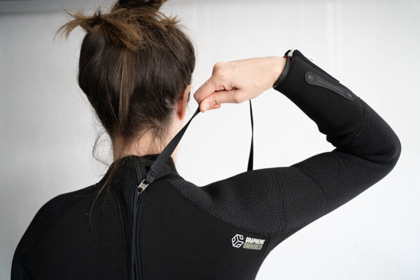 BARE Evoke Back Zipper Pull DIVEIN tester pulling the back zipper leash on the black BARE Evoke wetsuit