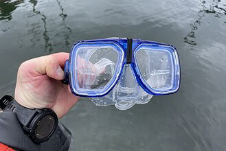 Our tester holding the blue Promate Scope prescription mask up over the water after a dive