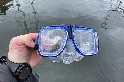 Our tester holding the blue Promate Scope prescription mask up over the water after a dive
