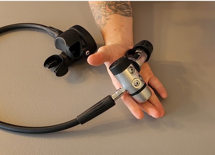 Our reviewer holding the Brut Pro first stage in one palm with the second stage beside it