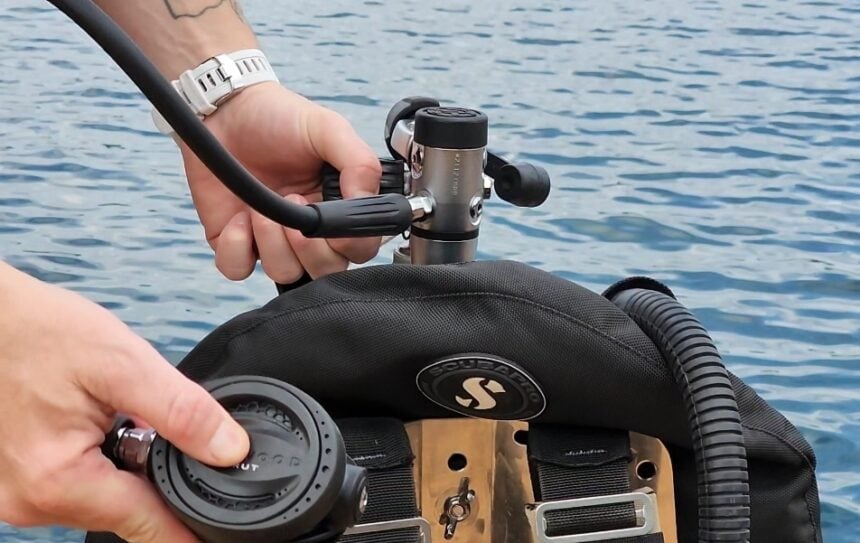 Our tester running a pre-dive check on the Brut Pro regulator beside the water