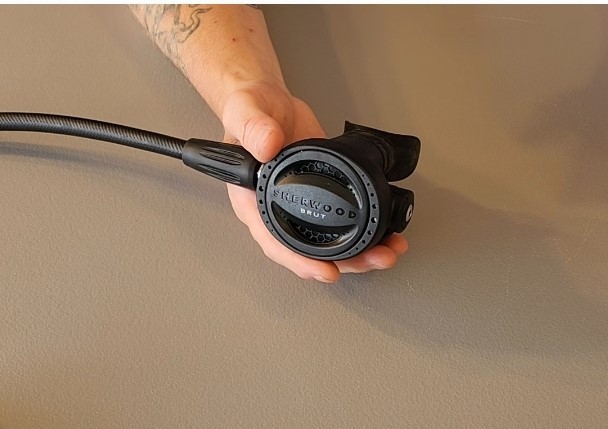Our tester holding the Sherwood Brut Pro second stage to show its size in one hand