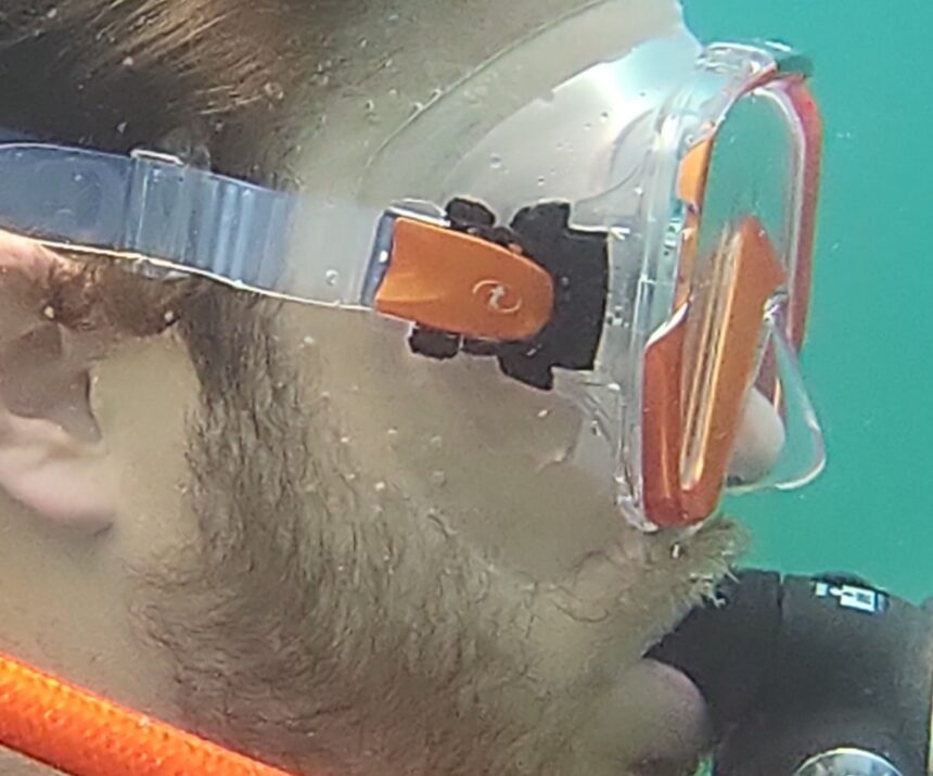 Close-up of the TUSA Freedom Elite skirt sealing against a diver's stubbled cheek underwater