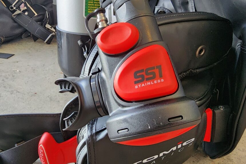 Close-up of the red Atomic Aquatics SS1 Safe Second inflator mounted on the BC2 corrugated hose