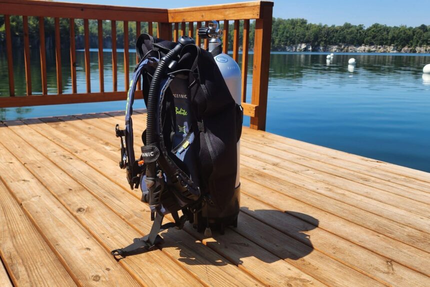 Oceanic Biolite BCD mounted on a tank and standing on a wooden dock beside a quarry lake