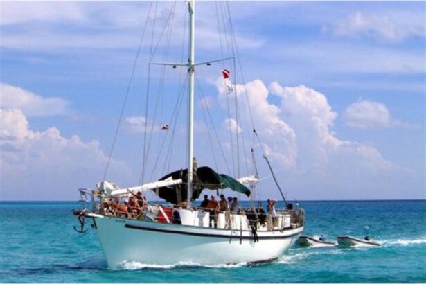 Blackbeard's Sea Explorer motoring across turquoise water with divers on deck and two tenders in tow