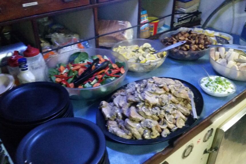 Buffet-style lunch spread of salad, roasted vegetables and chicken laid out on the Sea Explorer's galley counter