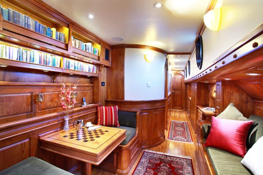 wood paneled lounge aboard the Adelaar with a chess table and bookshelves