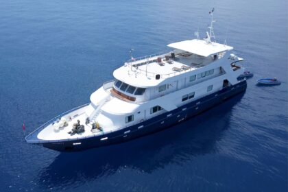 Infiniti liveaboard yacht at anchor viewed from above with two tenders alongside
