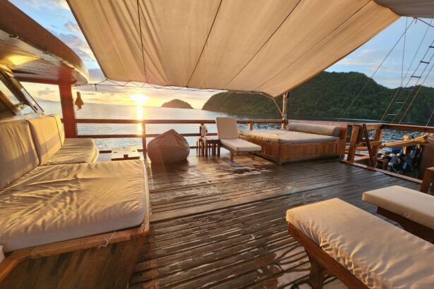 Shaded outdoor lounge deck on Damai I with daybeds overlooking the sea at sunset
