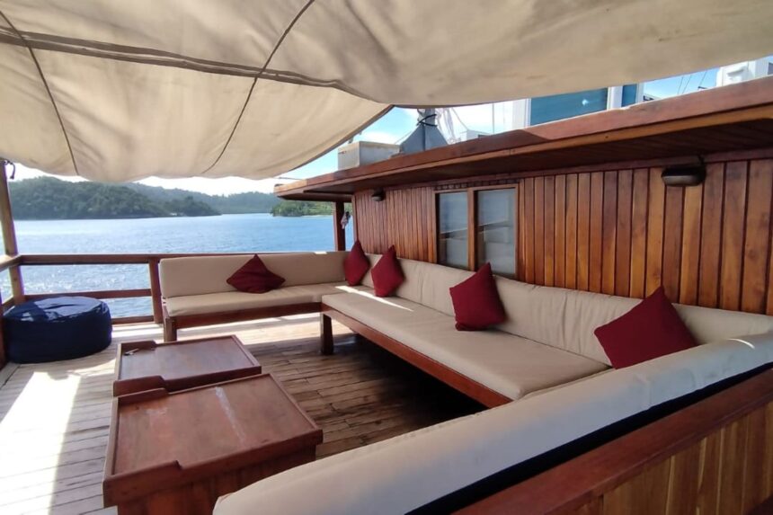 Outdoor deck seating with red cushions overlooking the coastline from the Damai I