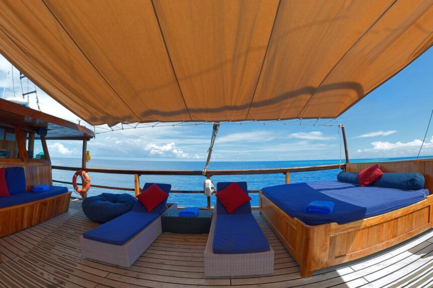 Shaded sundeck with blue loungers and ocean views aboard the Damai I