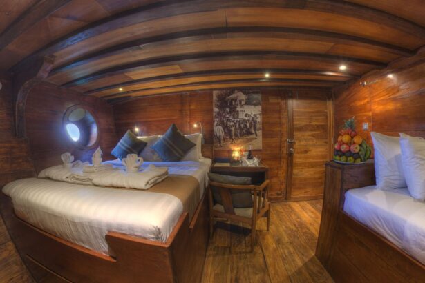 Wood paneled cabin aboard the Damai II with a large bed and porthole