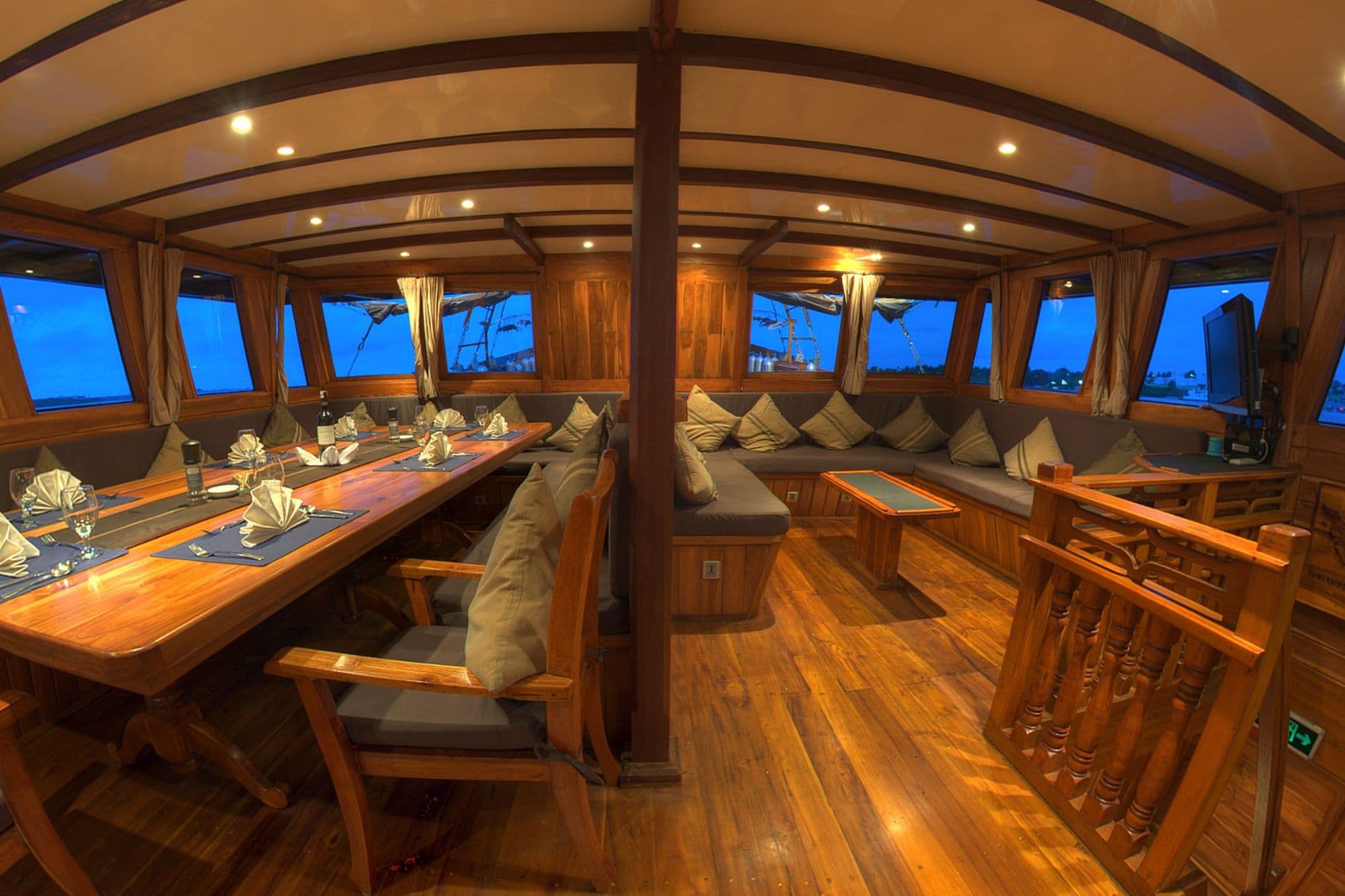 Indoor dining salon with a long table aboard the Damai I liveaboard