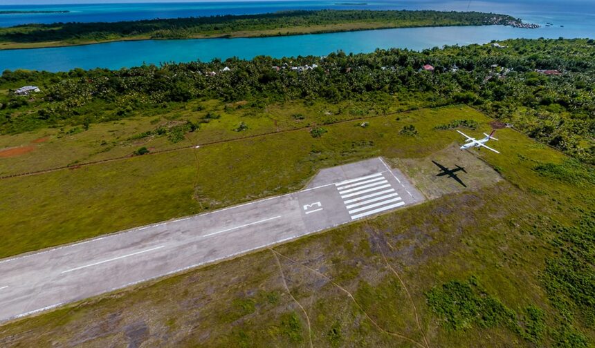 aerial view of Wakatobi's grass airstrip beside a turquoise lagoon